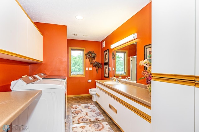 laundry room featuring light tile patterned flooring, washer and clothes dryer, and sink