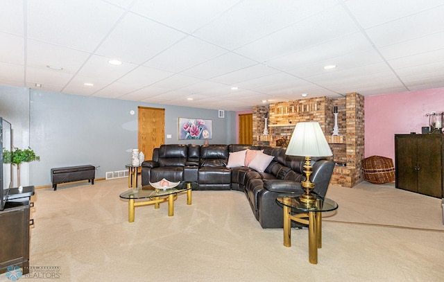 carpeted living room featuring brick wall and a paneled ceiling