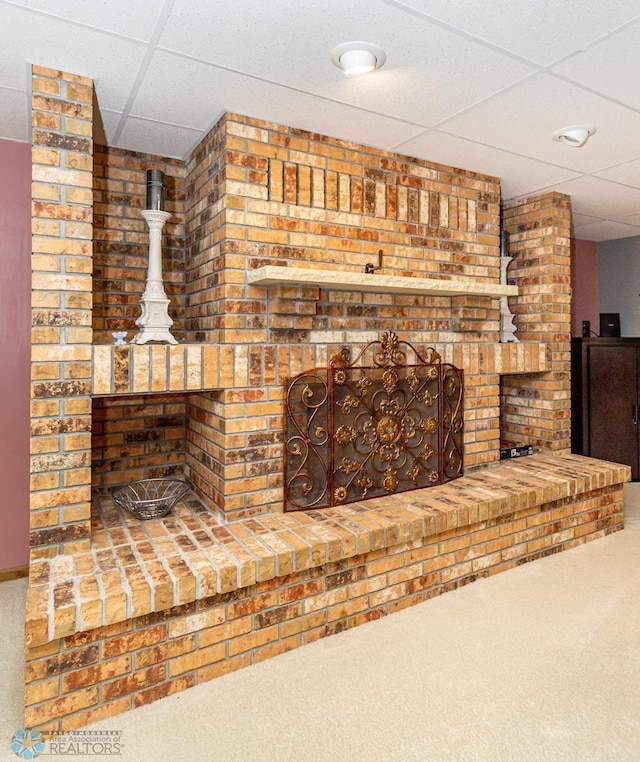 interior space with brick wall and a paneled ceiling