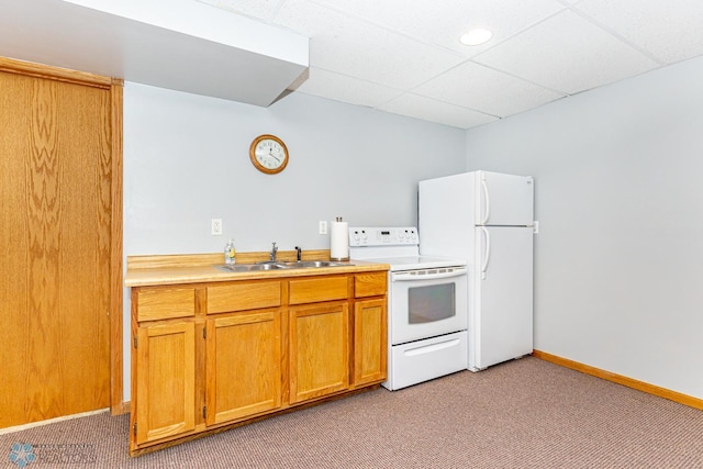 kitchen with sink, light carpet, white appliances, and a paneled ceiling