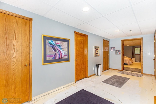 hallway with a paneled ceiling