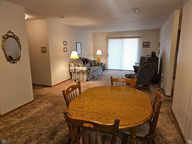 dining area featuring carpet flooring and a textured ceiling