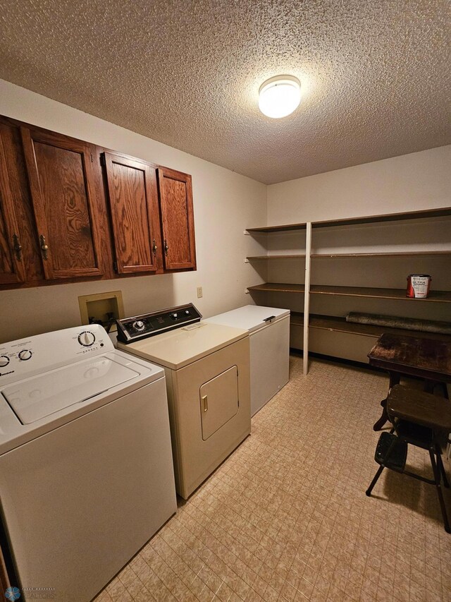 laundry area with light tile patterned flooring, separate washer and dryer, cabinets, and a textured ceiling