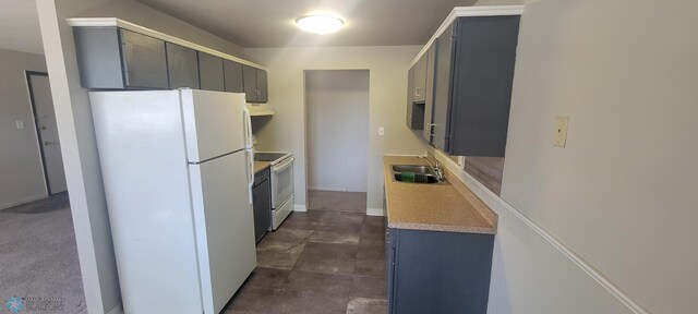 kitchen with sink, dark tile patterned flooring, white appliances, and gray cabinets