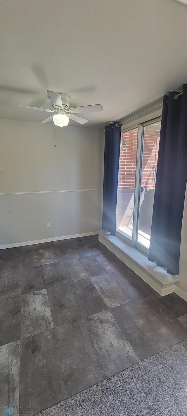 tiled spare room with ceiling fan