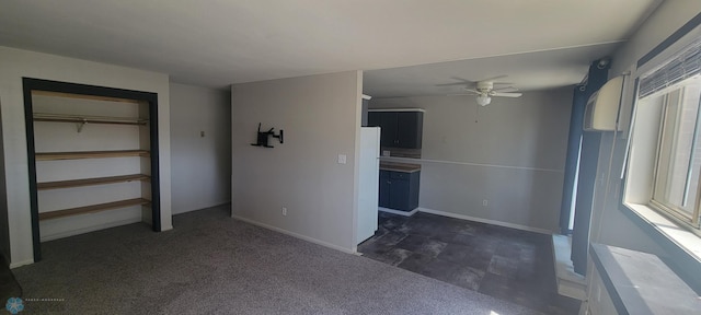 interior space featuring dark colored carpet and ceiling fan