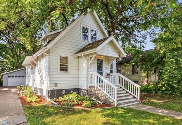 bungalow-style home featuring a garage and an outbuilding