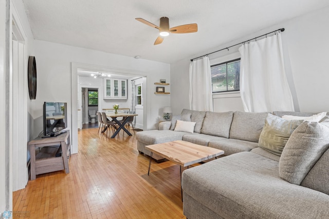 living room with plenty of natural light, ceiling fan, and light wood-type flooring