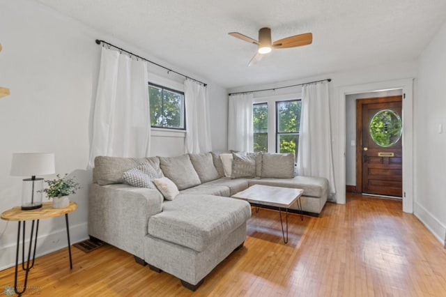 living room featuring ceiling fan and light hardwood / wood-style flooring