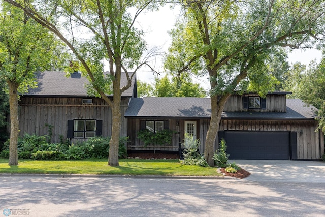 view of front of house featuring a garage and a front lawn