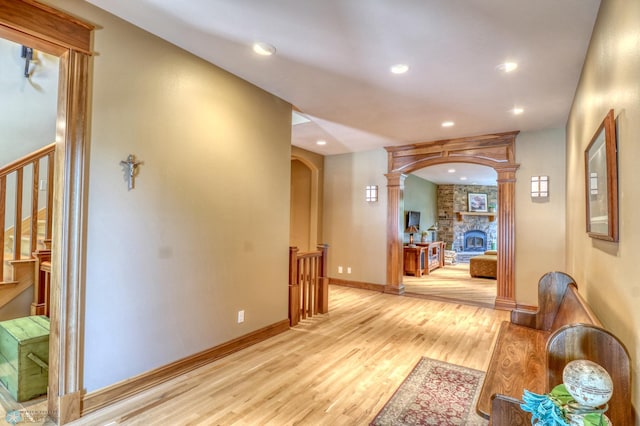 hallway featuring decorative columns and light hardwood / wood-style floors