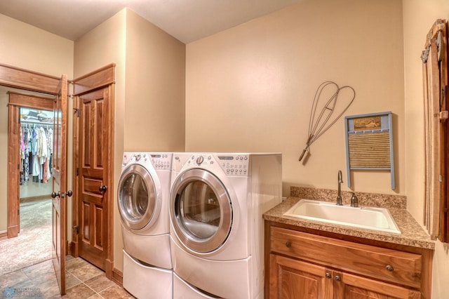 laundry area with cabinets, light tile patterned floors, washer and dryer, and sink