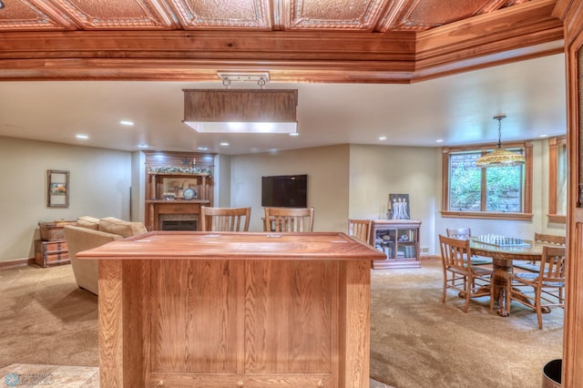 kitchen featuring light carpet, pendant lighting, and wood counters