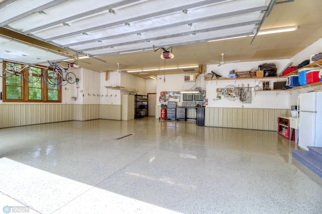 garage featuring white refrigerator and a garage door opener