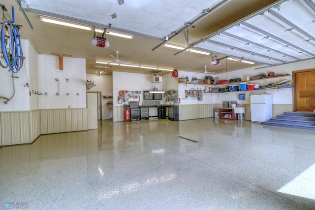 garage with a garage door opener and white fridge