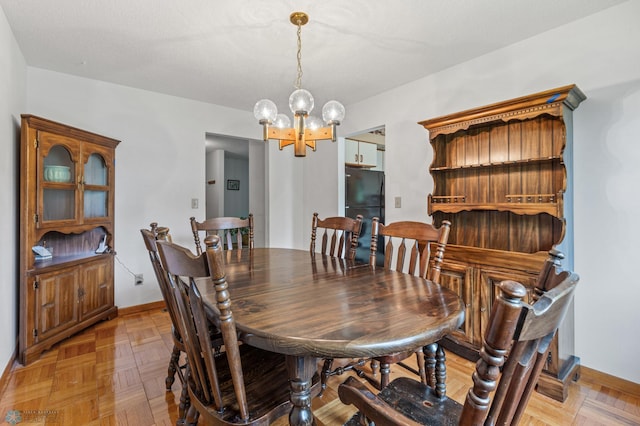 dining space featuring a notable chandelier and light parquet floors