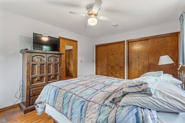 bedroom with two closets, ceiling fan, and light wood-type flooring