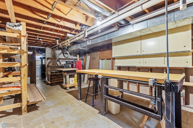 basement featuring light tile patterned floors and a workshop area