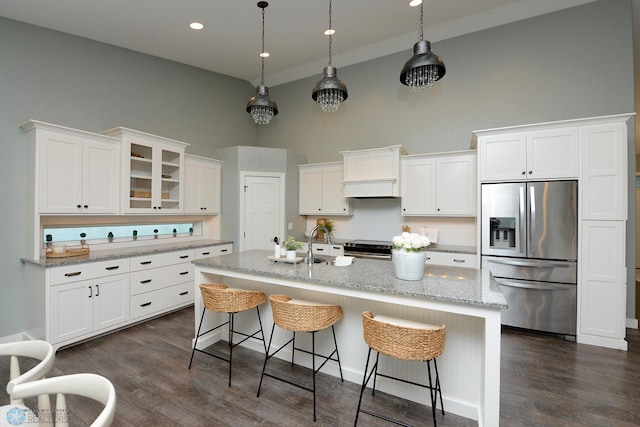 kitchen featuring white cabinetry, a high ceiling, dark wood-type flooring, backsplash, and appliances with stainless steel finishes