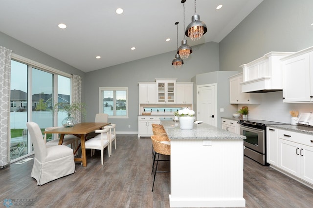 kitchen with white cabinetry, stainless steel range with electric stovetop, backsplash, a center island, and wood-type flooring