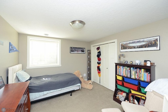 carpeted bedroom with a closet and a textured ceiling