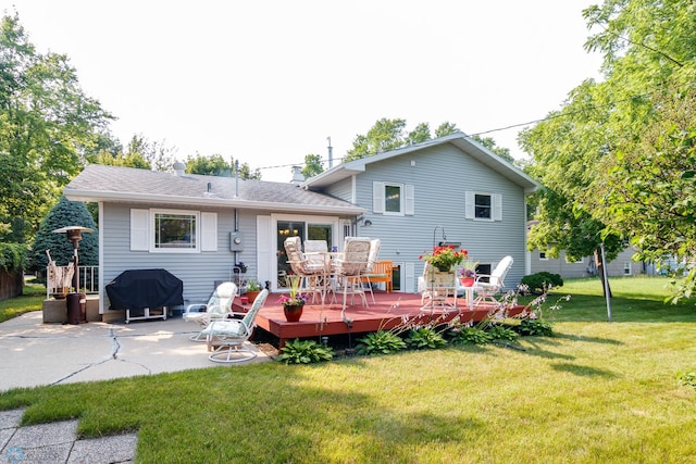 rear view of house with a deck and a yard