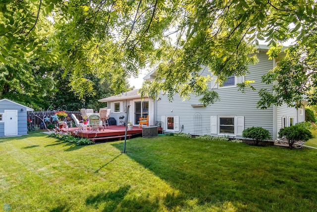 back of house featuring a yard, a wooden deck, a storage shed, and central air condition unit