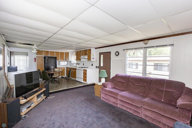 tiled living room with a paneled ceiling and ceiling fan