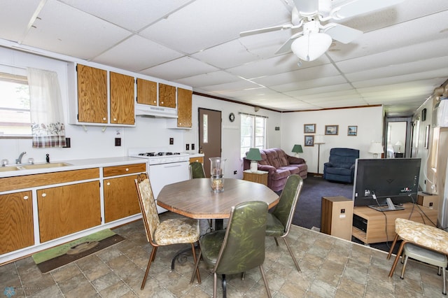 dining area featuring sink, tile patterned flooring, a drop ceiling, and a healthy amount of sunlight