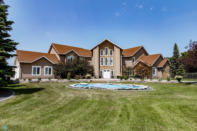 rear view of property featuring a lawn