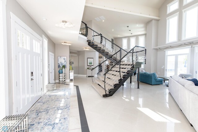 foyer featuring light tile patterned floors and a high ceiling