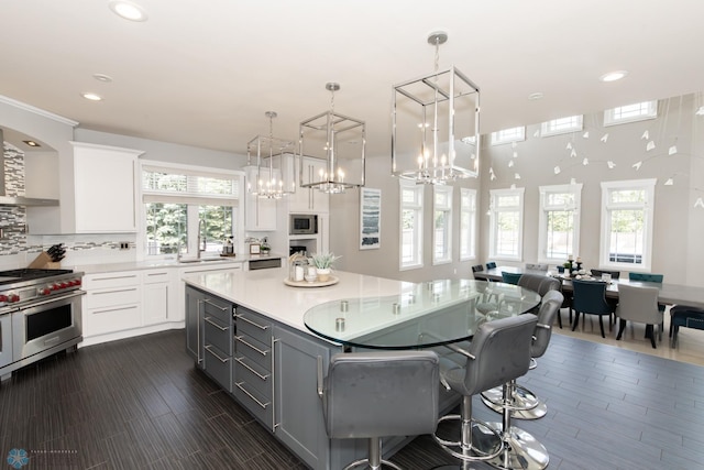 kitchen featuring white cabinetry, stainless steel appliances, tasteful backsplash, and a center island