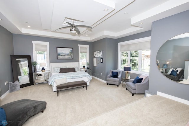 bedroom featuring carpet, ceiling fan, and a raised ceiling