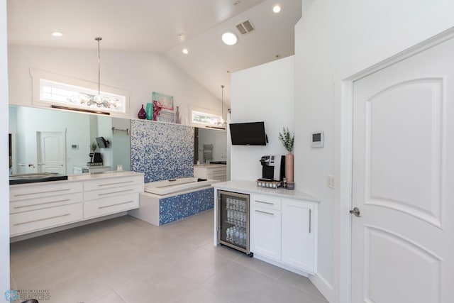 interior space with beverage cooler, tile patterned floors, a tub to relax in, and vanity