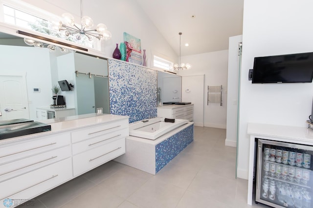 bathroom with tiled tub, tile patterned floors, vanity, and wine cooler