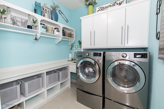 laundry area featuring cabinets, independent washer and dryer, and light tile patterned floors