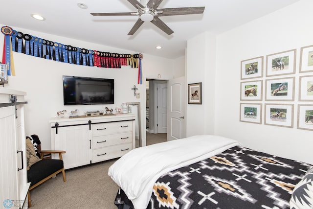 carpeted bedroom featuring a barn door and ceiling fan