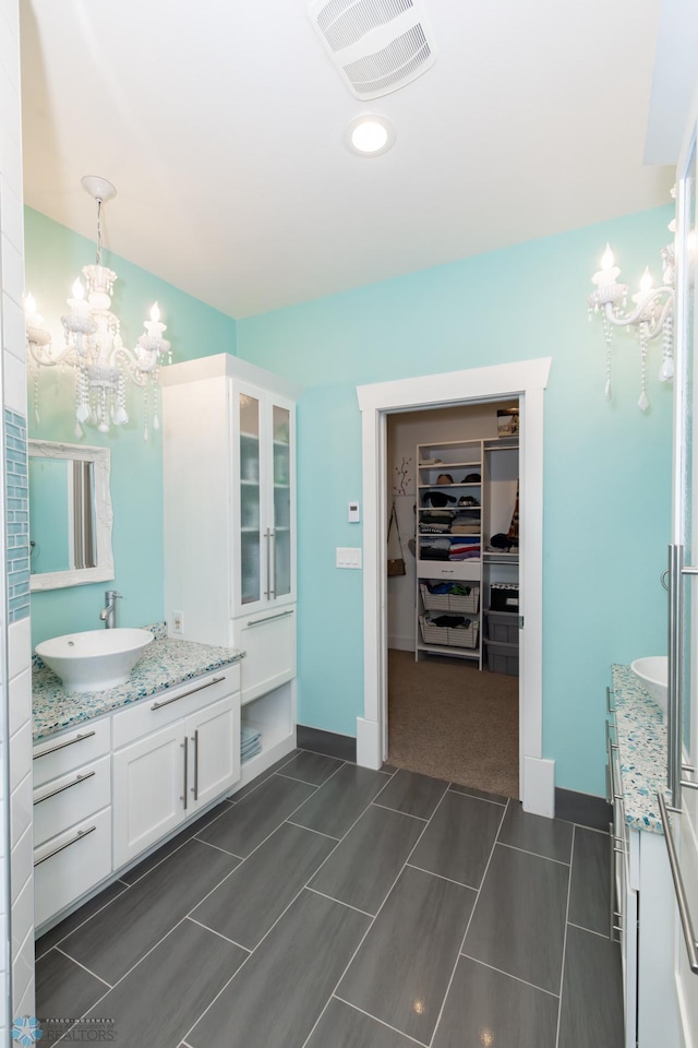 bathroom featuring vanity, a chandelier, and tile patterned floors