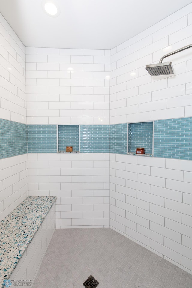 bathroom featuring tile walls and a shower