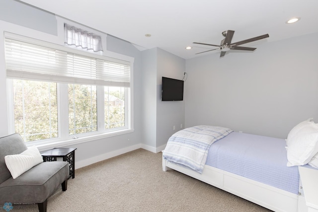 carpeted bedroom featuring multiple windows and ceiling fan