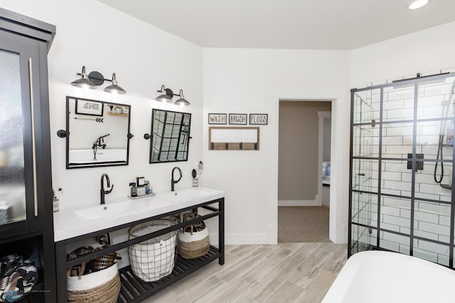 bathroom featuring dual vanity, wood-type flooring, and a bathtub