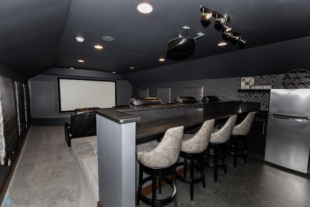 home theater room with lofted ceiling and track lighting