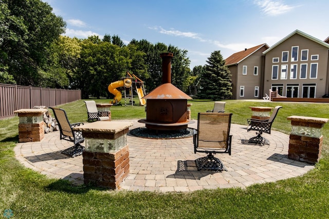 view of patio with a playground and a hot tub