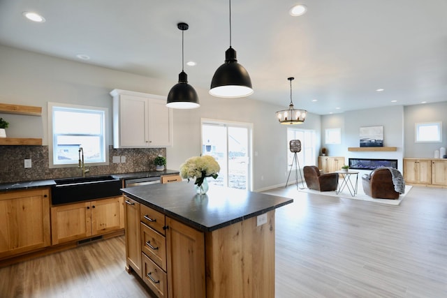 kitchen featuring plenty of natural light, a center island, white cabinetry, and light hardwood / wood-style flooring