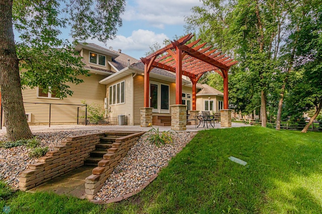 back of property with a pergola, a patio area, and a yard