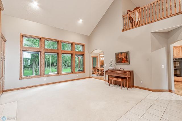 living area with light carpet and high vaulted ceiling