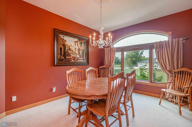 carpeted dining area featuring a notable chandelier