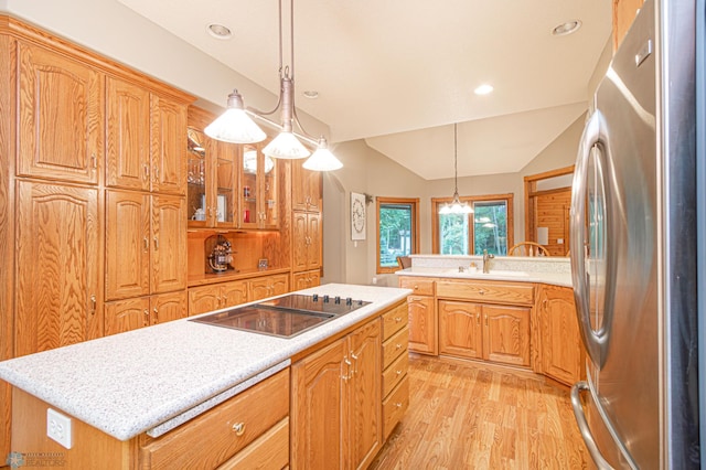 kitchen featuring vaulted ceiling, sink, stainless steel refrigerator, light hardwood / wood-style floors, and black electric cooktop