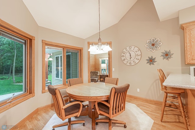 dining room with a notable chandelier, high vaulted ceiling, a healthy amount of sunlight, and light wood-type flooring