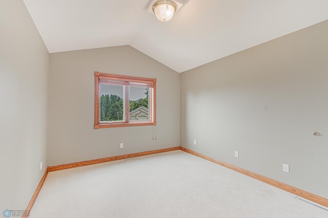 spare room with carpet floors and lofted ceiling